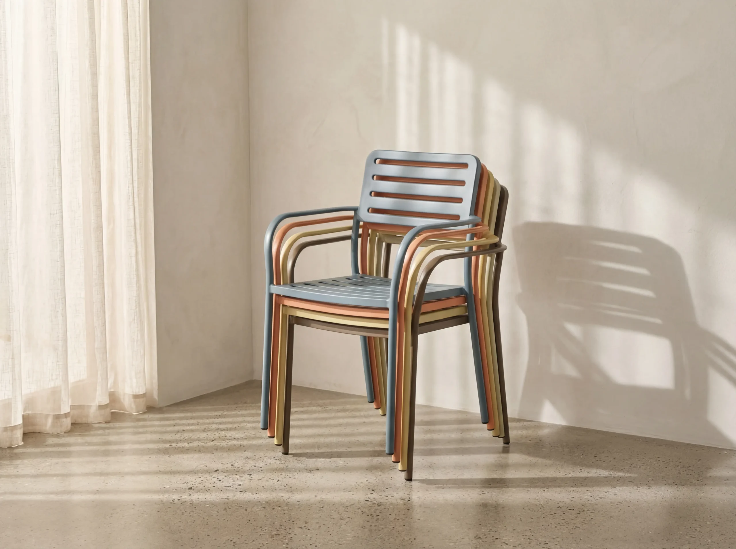 Powder-coated metal outdoor dining chairs stacked in several colours